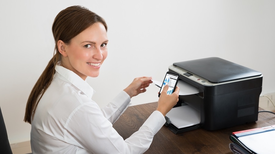 Young Happy Businesswoman Using Mobile Phone For Printing Graph Paper